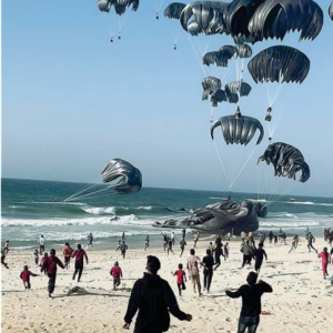 Palestinesi corrono verso i paracadute con gli aiuti umanitari lanciati dagli Usa (Afp)